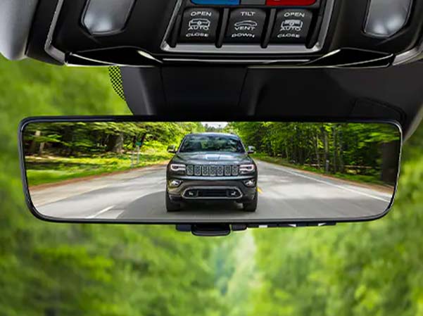 2023 Jeep Grand Cherokee L shown driving in the rear view mirror