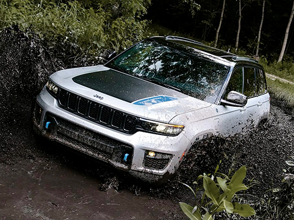 Display The 2023 Jeep Grand Cherokee 4xe being driven through muddy water.