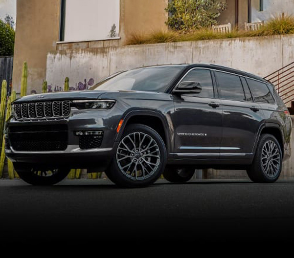 The 2023 Jeep Grand Cherokee parked on a driveway with a building behind it