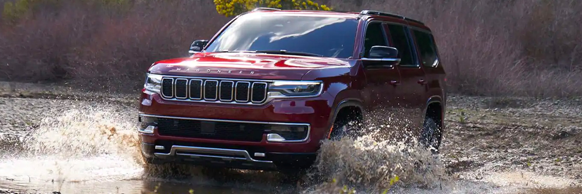 Front 3/4 shot of 2023 Wagoneer driving through water.