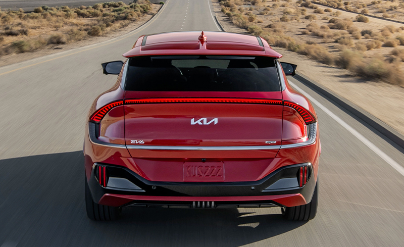 2023 Kia EV6 In Red, Driving Down A Desert Road Side-View