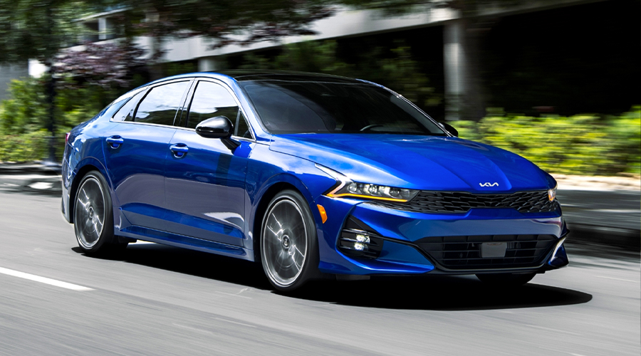 2023 Kia K5 GT Driving Fast Down A City Street Three-Quarter View