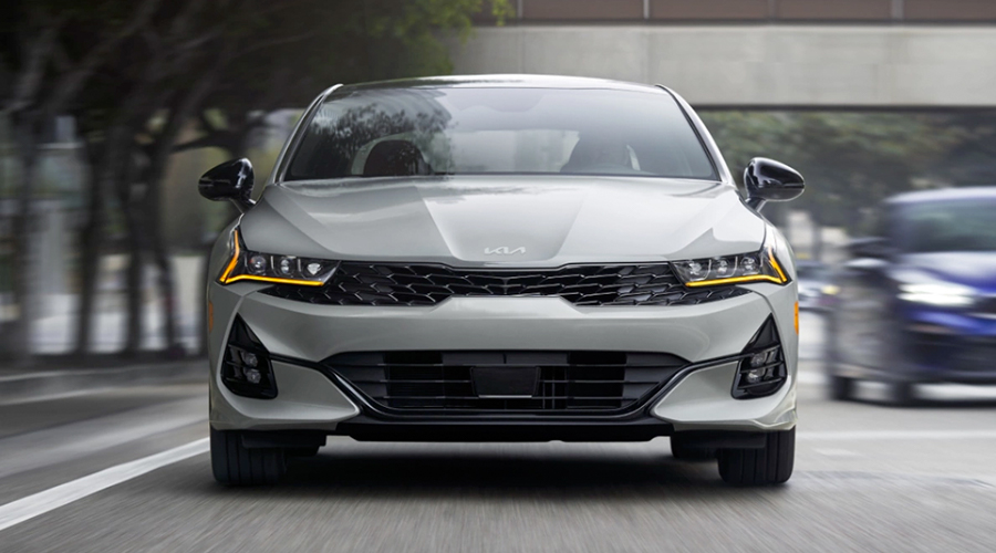 2023 Kia K5 Driving Down A Busy City Street Front View