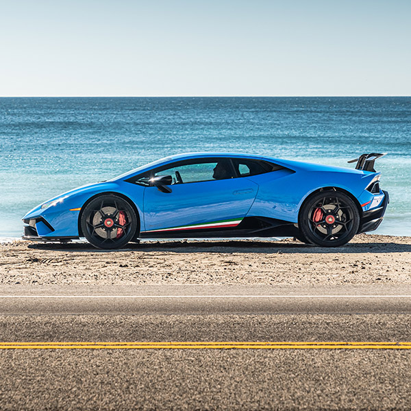 Side shot of Lamborghini Huracan parked in front of beach.