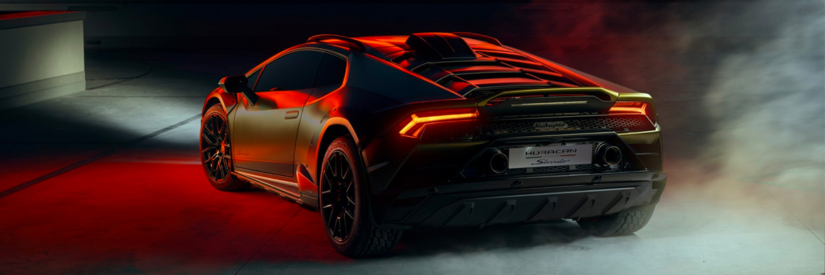 Rear 3/4 shot of Lamborghini Huracán Sterrato with red lighting background.