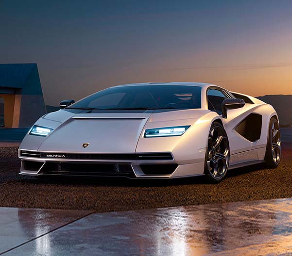Exterior shot of a Lamborghini Limited Series parked on a driveway with the headlights on.