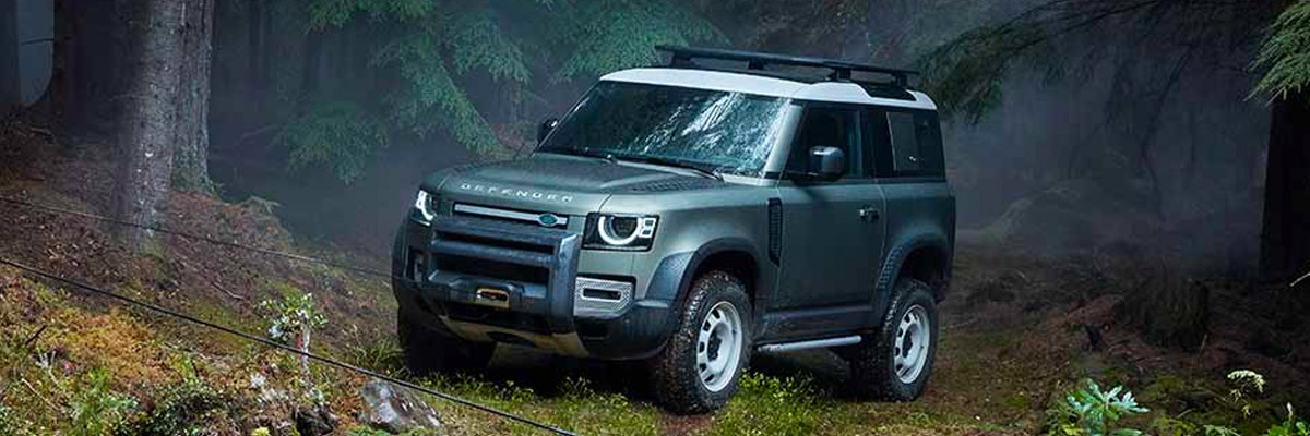 A 2023 Land Rover Defender parked in a forest.
