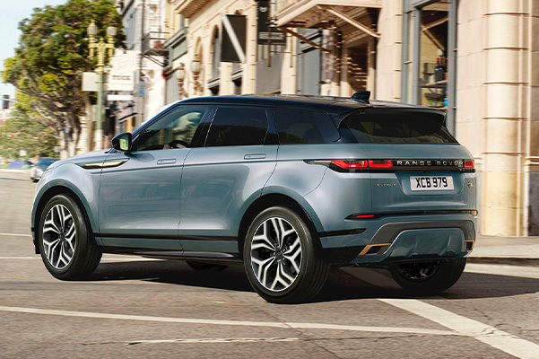Exterior shot of a 2023 Range Rover Evoque taking a turn in a city.