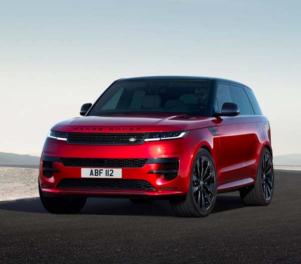 Exterior shot of a red 2023 Range Rover Sport parked in an empty lot.