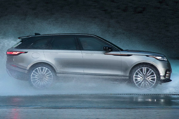 Exterior shot of a 2023 Range Rover Velar driving in water.