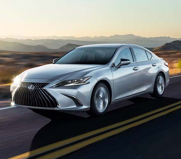 Exterior shot of a 2023 Lexus ES driving on a road with a desert in the background.