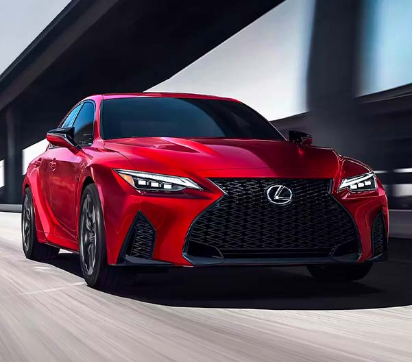 Exterior shot of a 2023 Lexus IS driving down a highway.