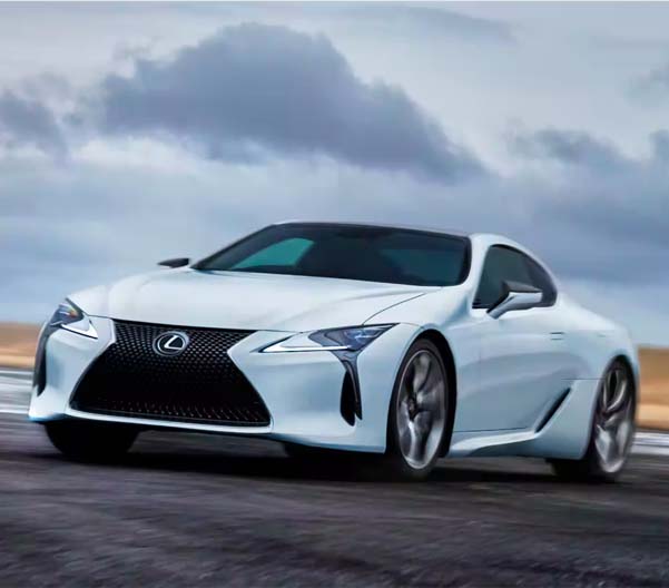 Exterior shot of a 2023 Lexus LC driving in an emnpty lot during a cloudy day.