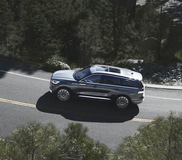 A 2023 Lincoln Aviator® is shown from above as it travels along a winding mountain road