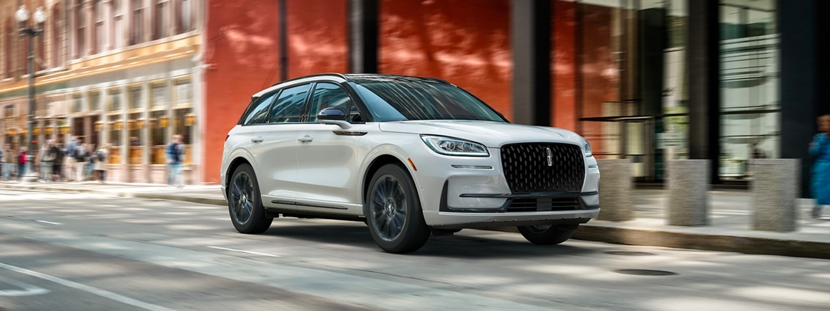A 2023 Lincoln Corsair® SUV with the available Jet Appearance Package is being driven in a city