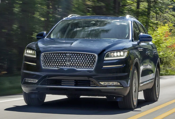 A 2023 Lincoln Black Label Nautilus® SUV is being driven along a country road
