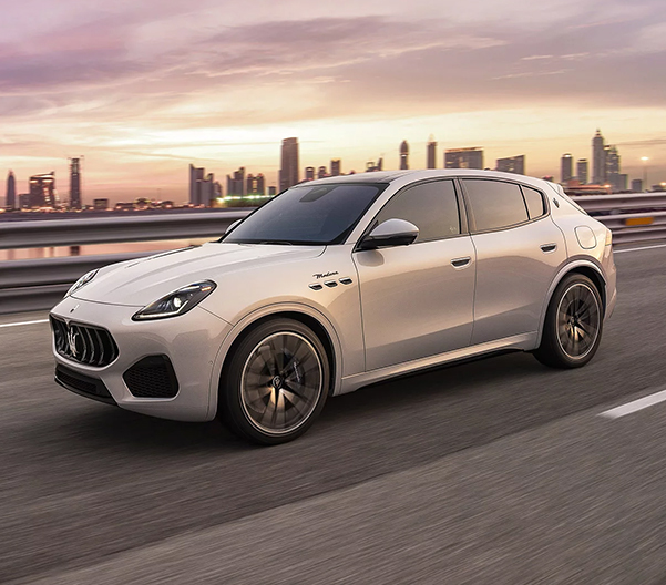 2023 Maserati Grecale driving on a highway with a city in the background