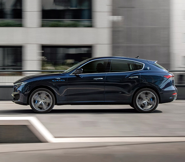 Side shot of 2023 Maserati Levante driving down city street.