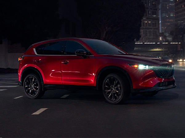 The 2023 Mazda CX-5 driving along the street at night