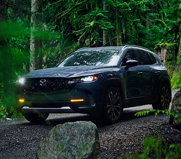 2023 Mazda CX-50 driving through a forest road