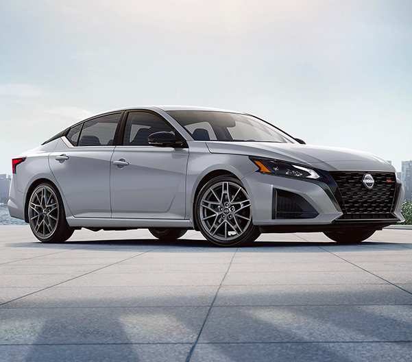 2023 Nissan Altima in white parked with city in background illustrating exterior design.