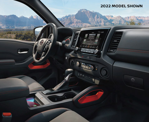 The steering wheel and center console of the  2022 Nissan Frontier