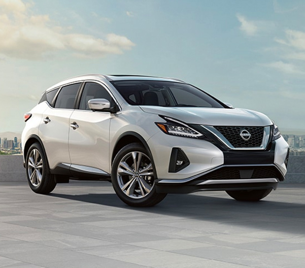 White 2023 Nissan Murano parked in front of city skyline during day.