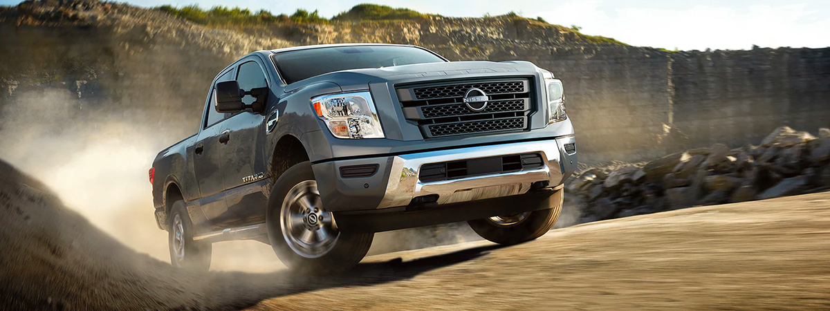 2023 Nissan TITAN XD crew cab going up a dirt road.
