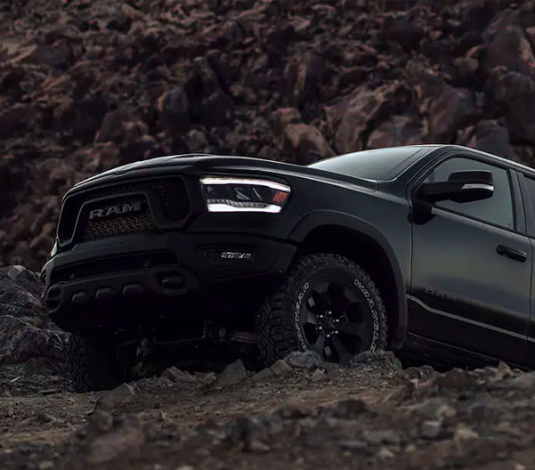 2022 RAM 1500 driving up a rocky terrain