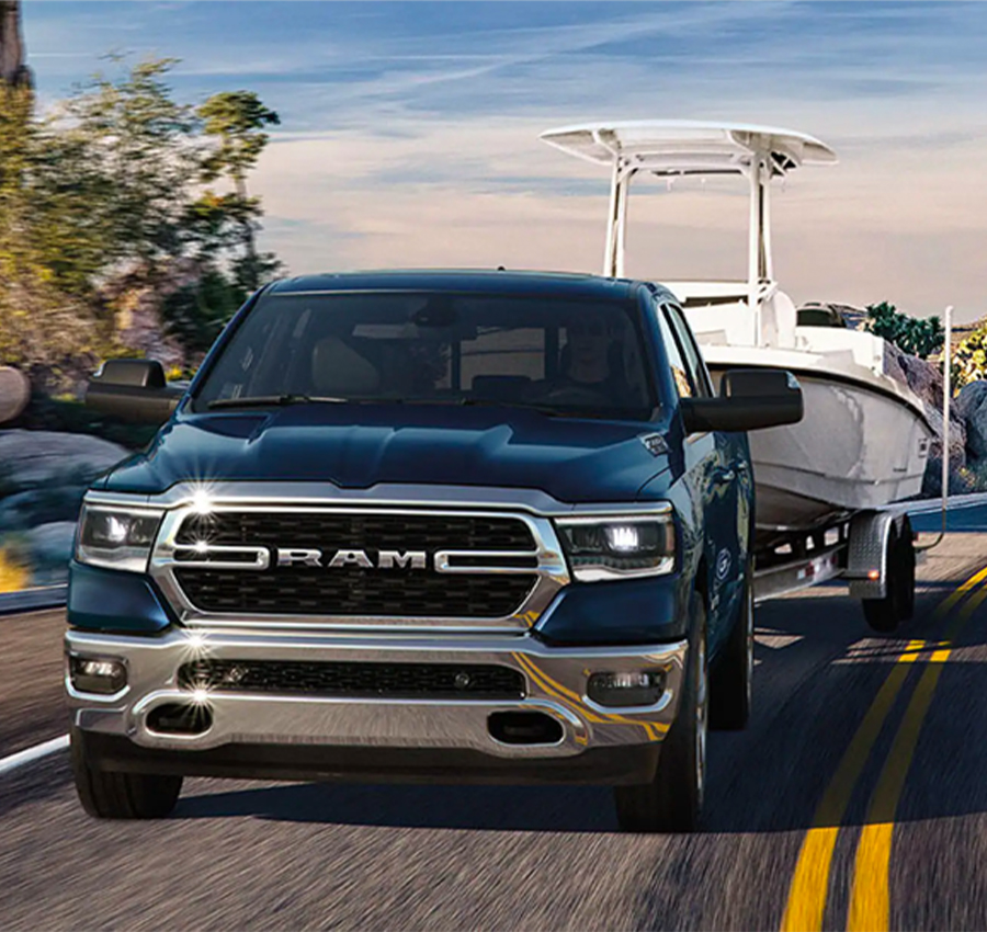 The 2023 RAM 1500 towing a motorboat.