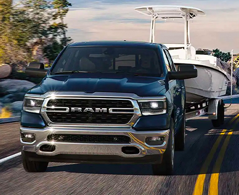 The 2023 Ram 1500 towing a motorboat.