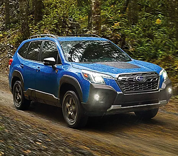 2023 Subaru Forester Wilderness shown in Geyser Blue driving on dirt road.