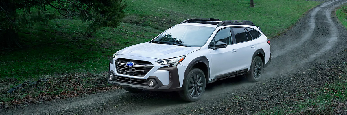 2023 Subaru Outback driving uphill on a rugged trail.