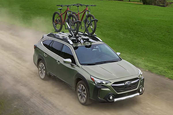 Exterior shot of a 2023 Subaru Outback driving on a dirt road.