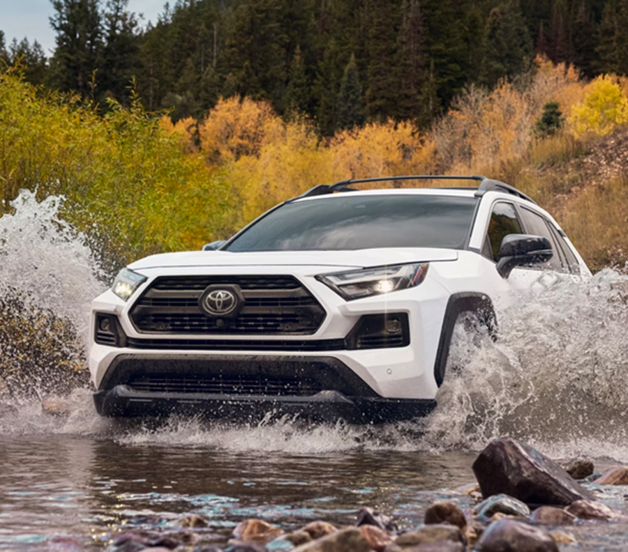 2023 RAV4 driving through a small body of water illustrating it's capabilities in multi-terrains