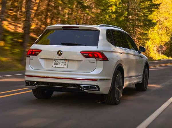 Exterior shot of a 2023 VW Tiguan driving down a scenic road