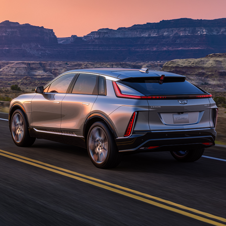 2024 Cadillac LYRIQ 7/8 Drivers side rear view of vehicle in motion on road with sunset
