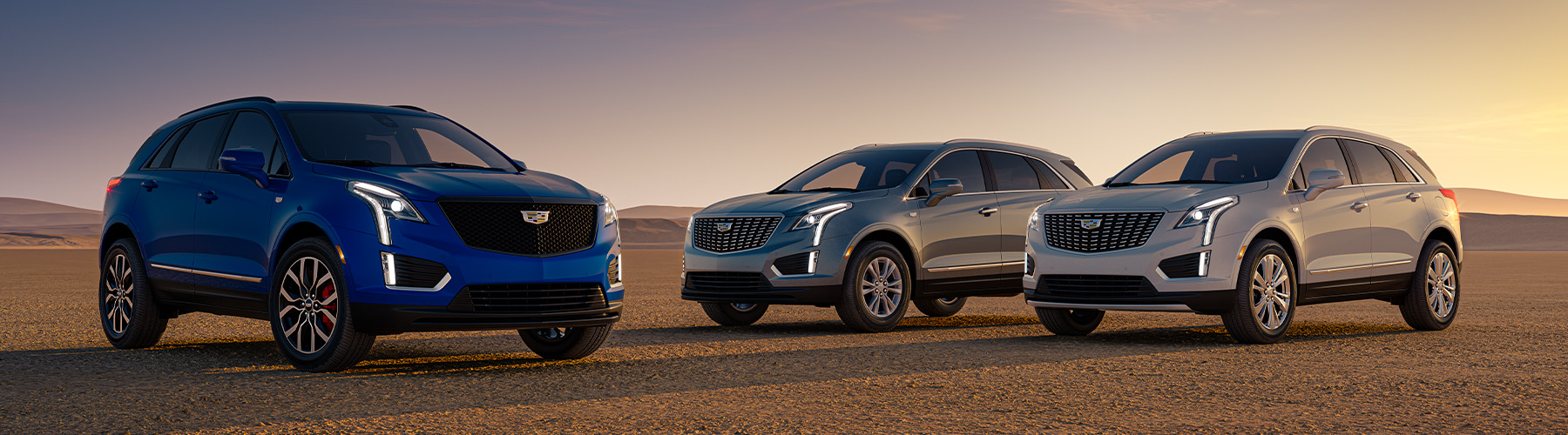 Cadillac 2024 XT5 pack shot; images featuring From Left to Right: 2024 XT5 Sport seen in Opulent Blue Metallic, 2024 XT5 Luxury seen in Argent Silver, and 2024 XT5 Premium Luxury seen in Crystal White Tricoat