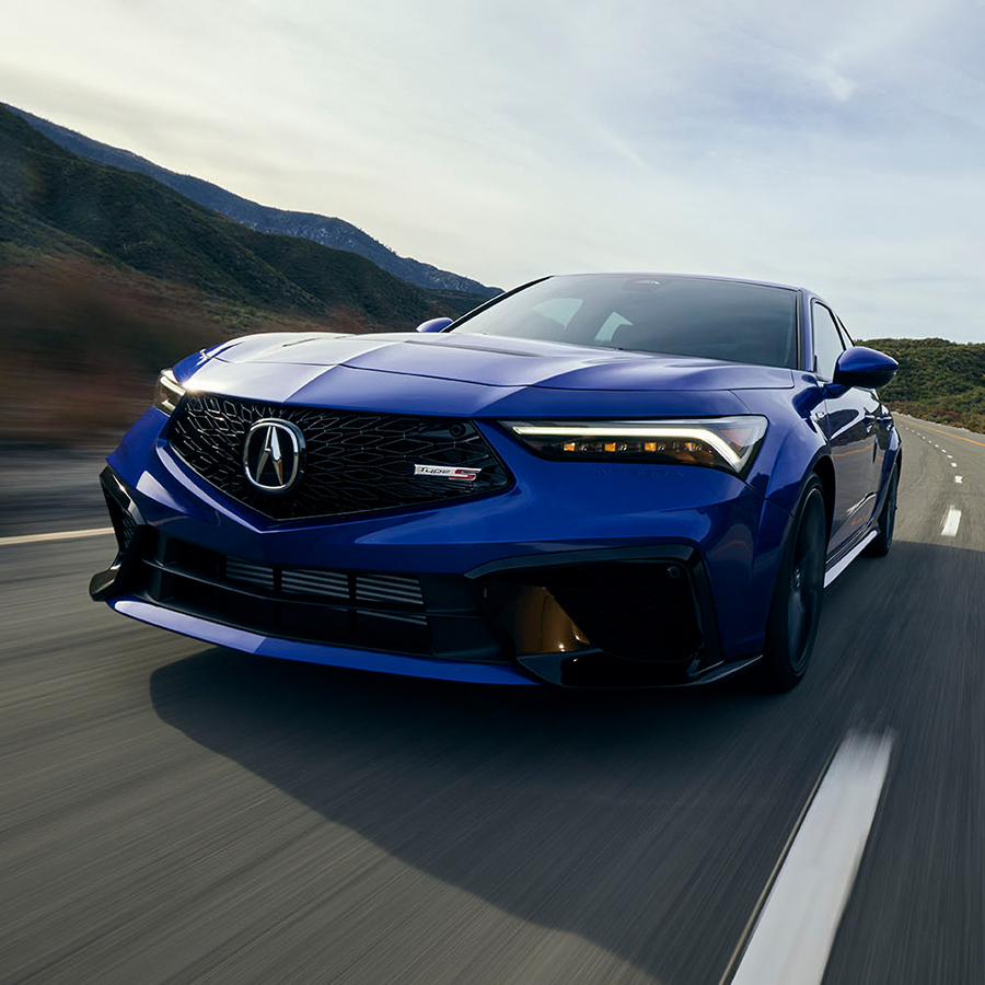 Rear view of the 2024 Acura Integra racing along a highway