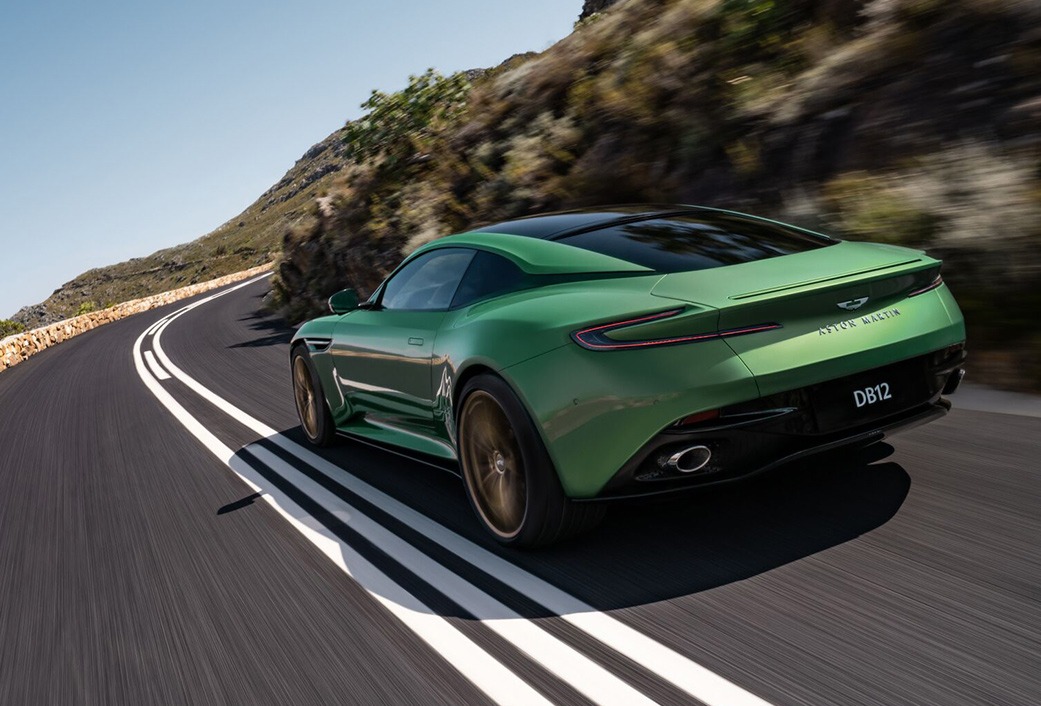 Rear view of a 2024 Aston Martin DB12 driving on a road