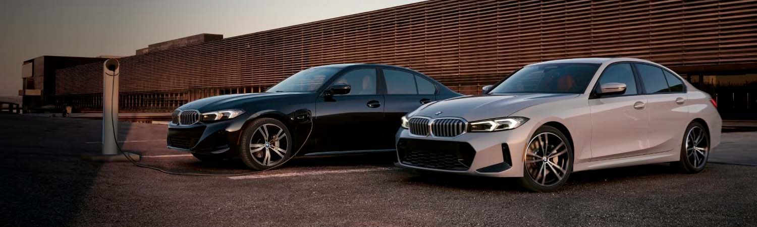 Two parked 2024 BMW 3 Series vehicles charging