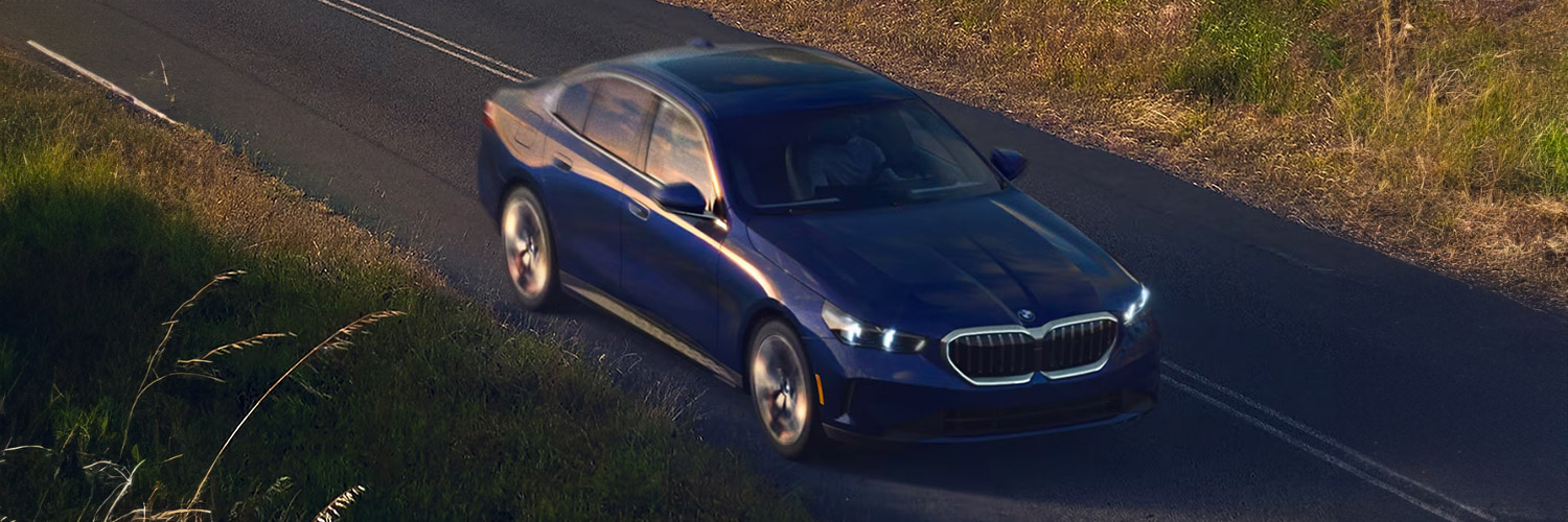 Overhead shot of the 2024 BMW 5-Series driving down road