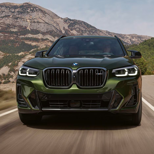 Fornt view of the 2024 BMW X3 driving down the road