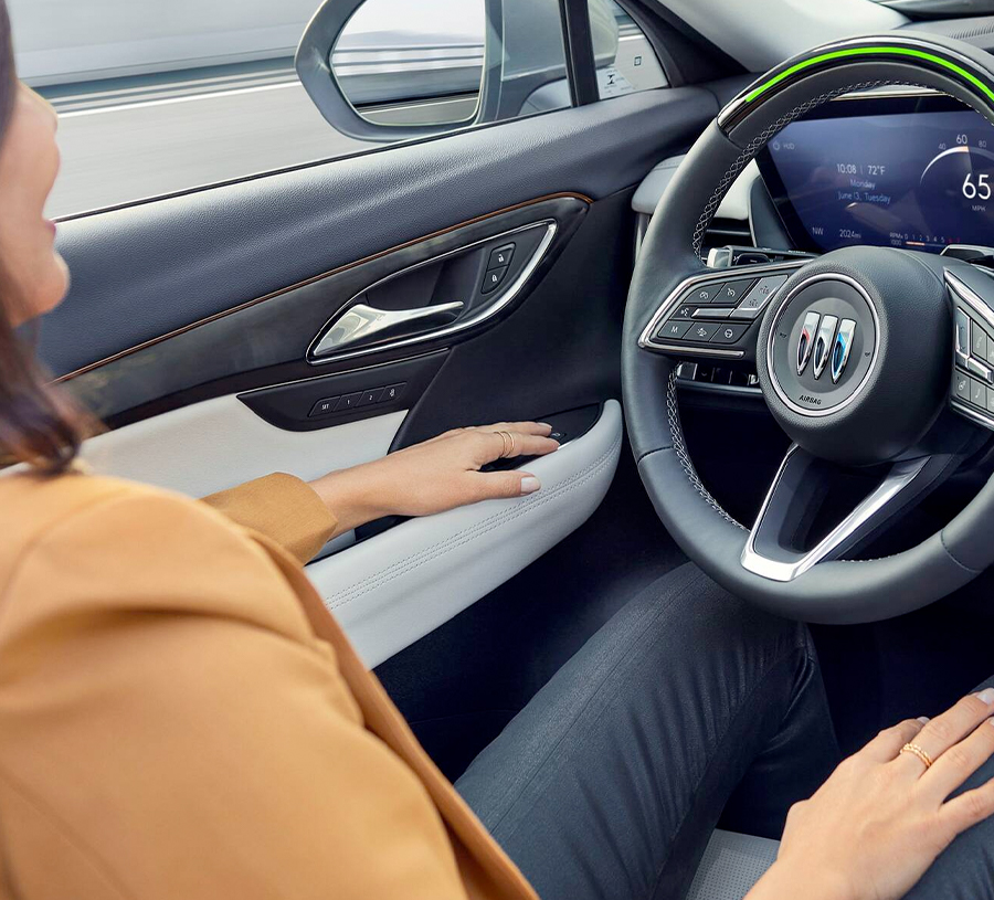 A Woman Sitting in the Driver's Seat of a New Buick Envision Using the Available Super Cruise Feature
