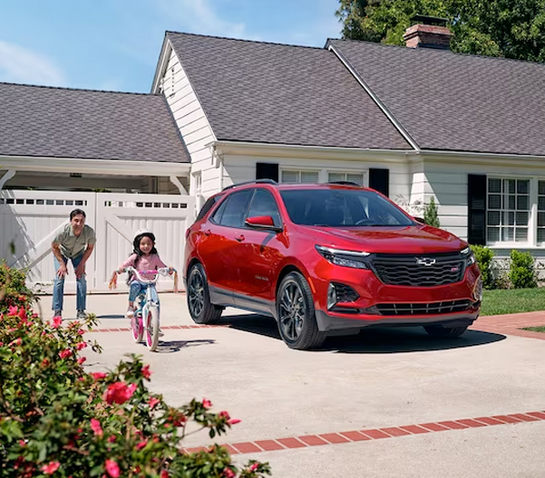 A Family of Three Enjoys Their Front Yard on a Sunny Day Around Their Equinox RS
