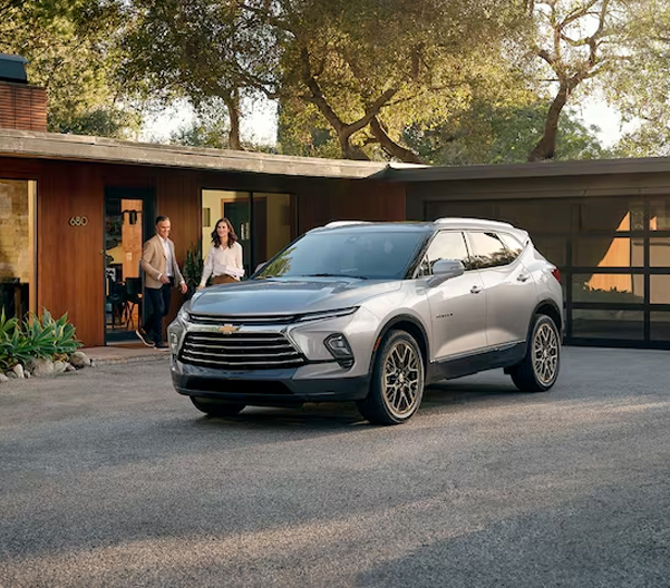 Front Side View of People Walking Out of Their House to Their 2024 Chevy Blazer