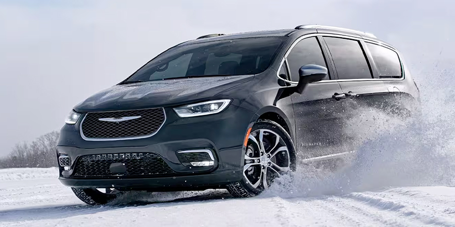 Display The 2024 Chrysler Pacifica Pinnacle being driven on a snow-covered surface.