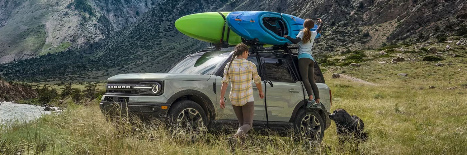 Side shot of 2024 Ford Bronco Sport with kayaks being taken off of roof