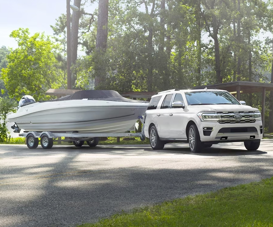 A 2024 Ford Expedition Platinum Max model towing a boat from a boat launch