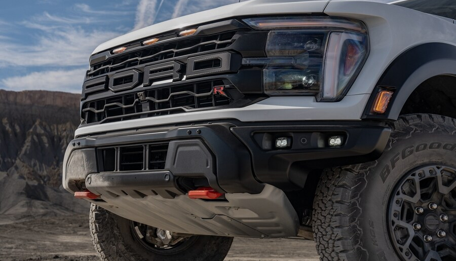 Close-up of the front end of a 2024 Ford F-150® Raptor R™ in Oxford White showing the front grille
